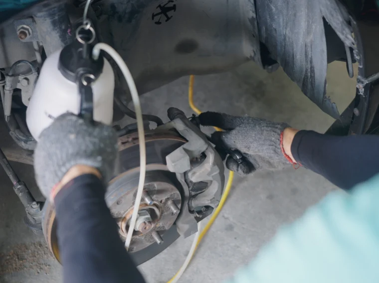Mechanic checking the brake components of a vehicle.